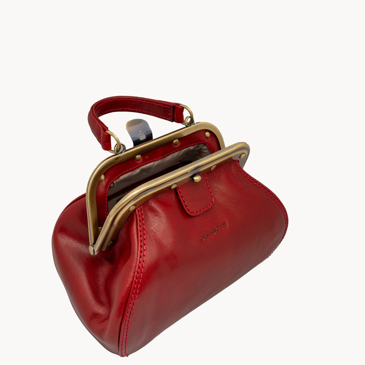 Red Gladstone style bag with metal clip opening and grad handle with detachable long strap.