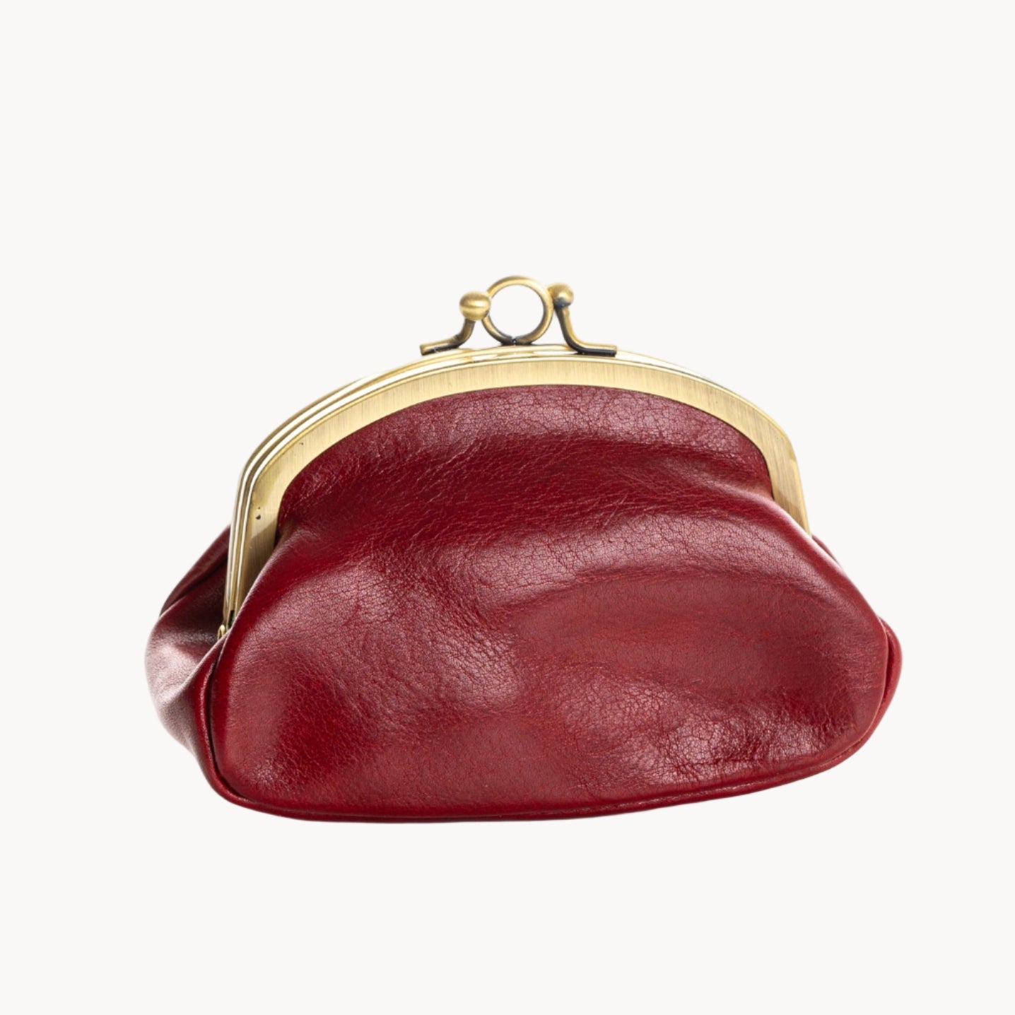 Red leather clutch with gold clasp on a white background