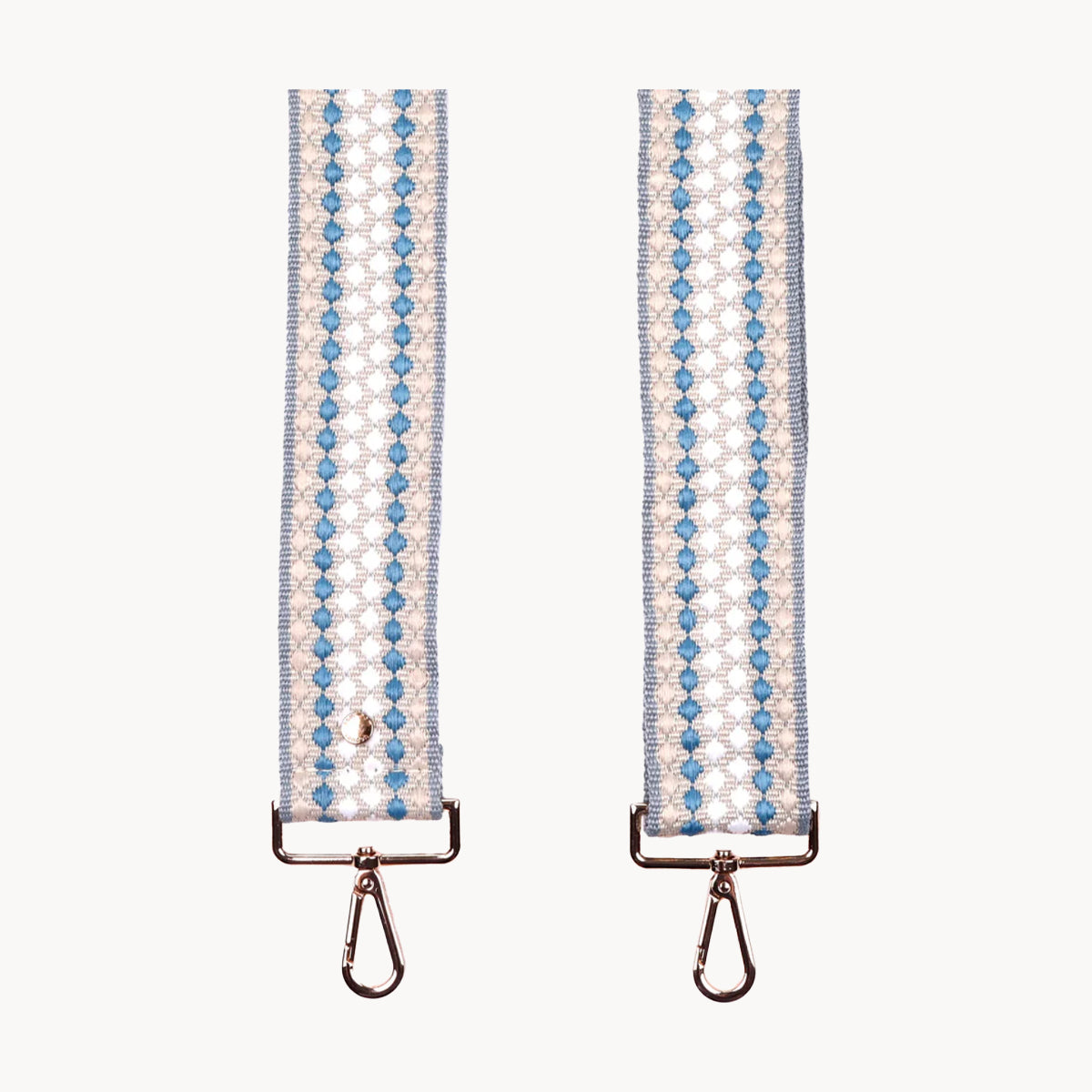 Two handbag straps with blue and white pattern on a white background