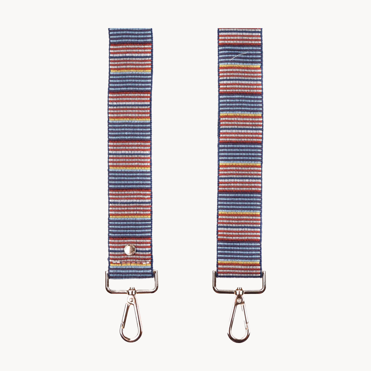 Two striped bag straps with metal hooks on a white background