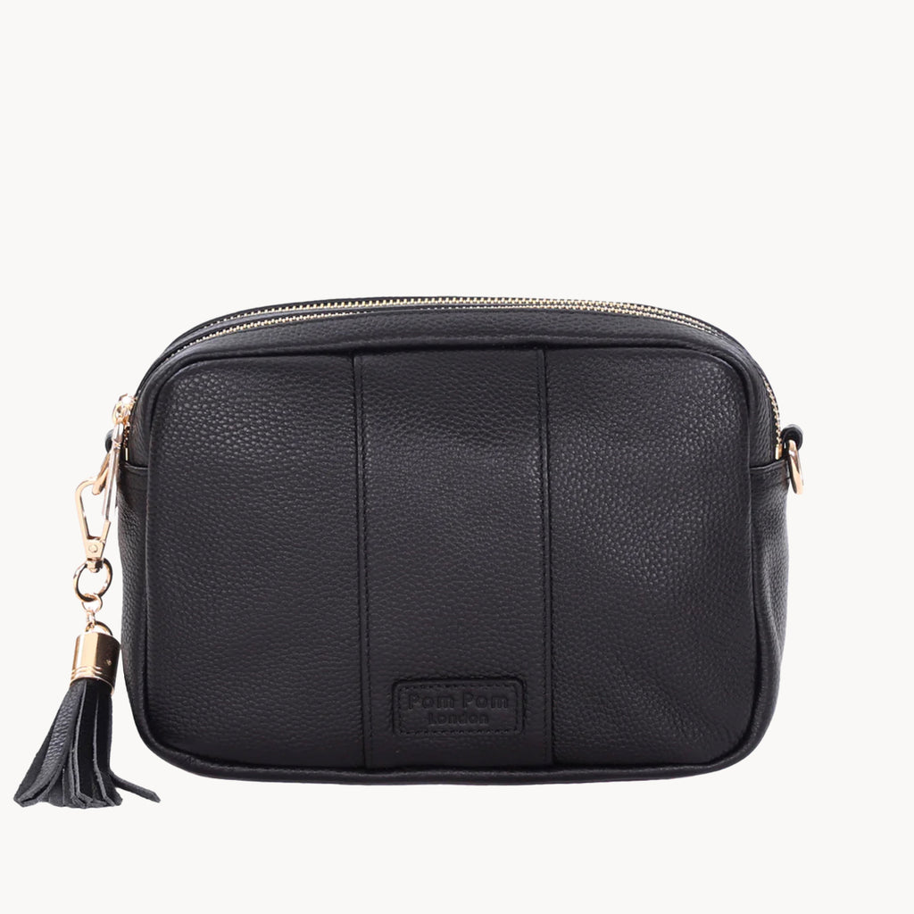Black leather crossbody bag with a tassel on a white background