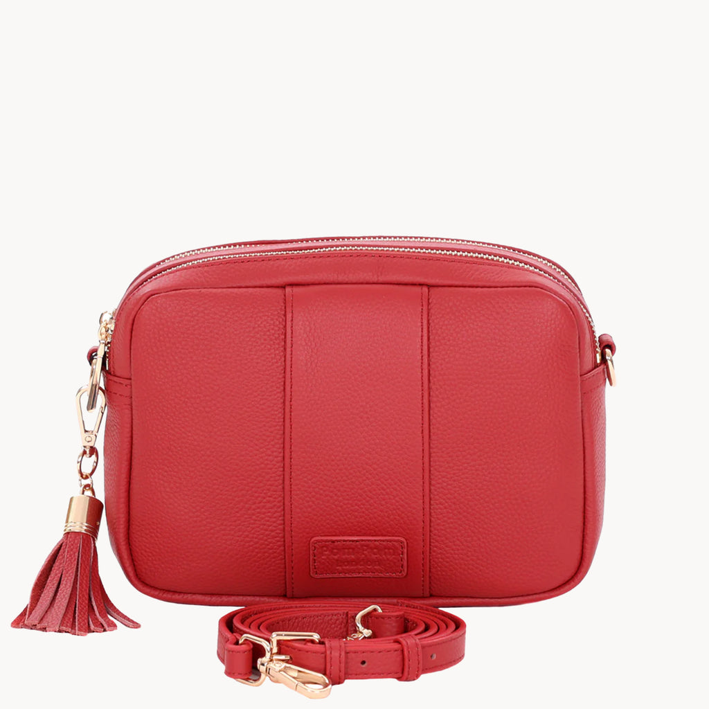 Red leather crossbody bag with a tassel on a white background