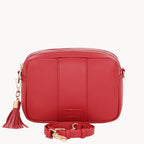 Red leather crossbody bag with a tassel on a white background