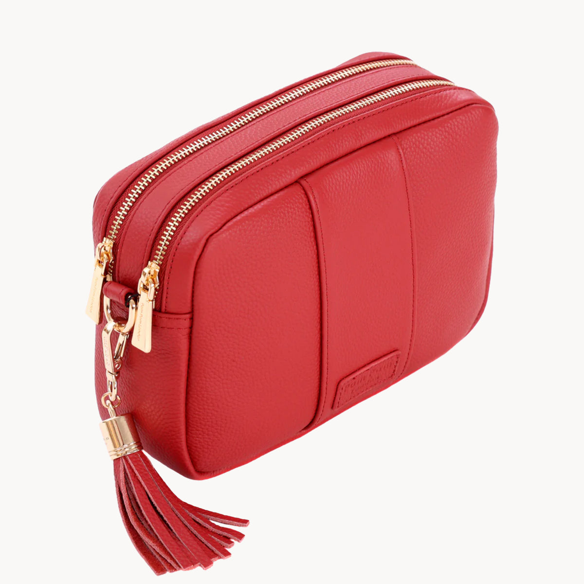 Red handbag with gold zipper and tassel on a white background