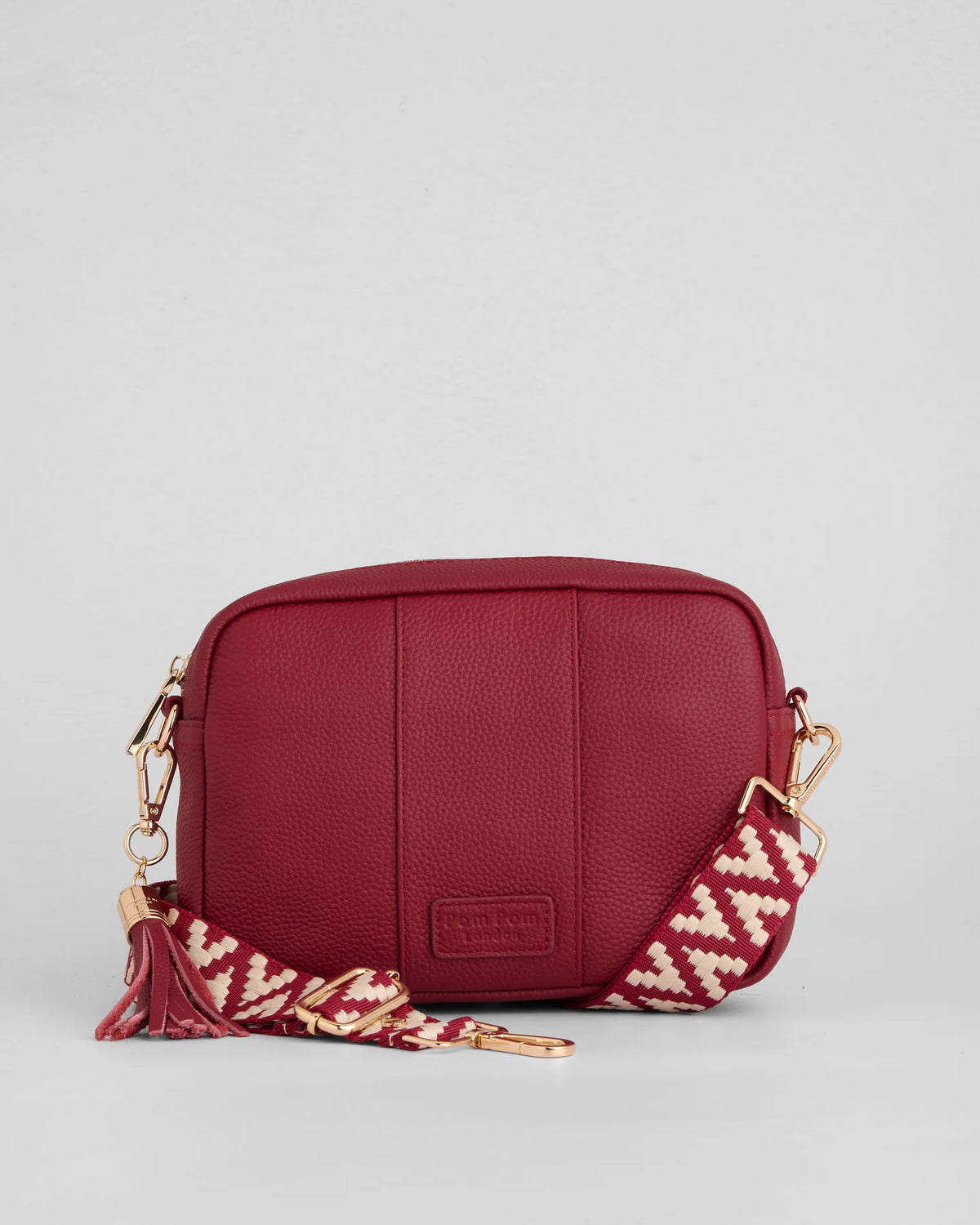 Burnt Rhubard red pebble leather crossbody bag with tassle and gold hardward with interchangable fabric strap