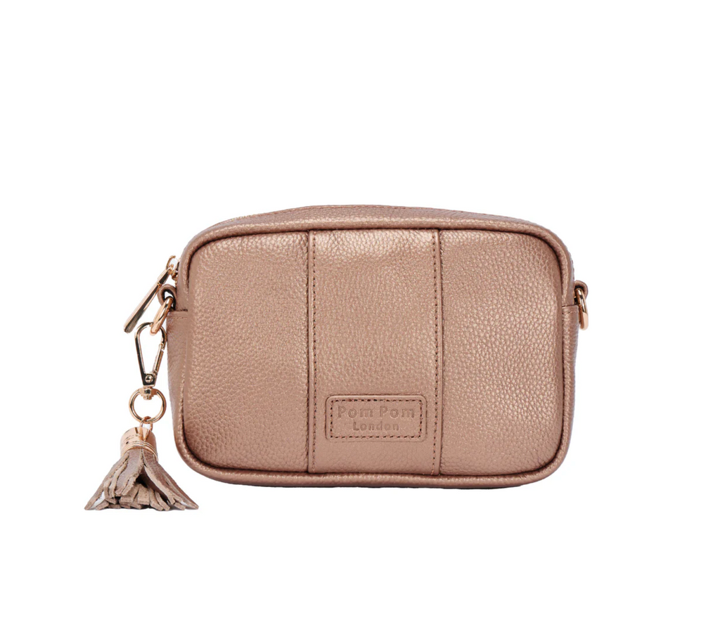 Bronze crossbody bag with a tassel charm on a white background