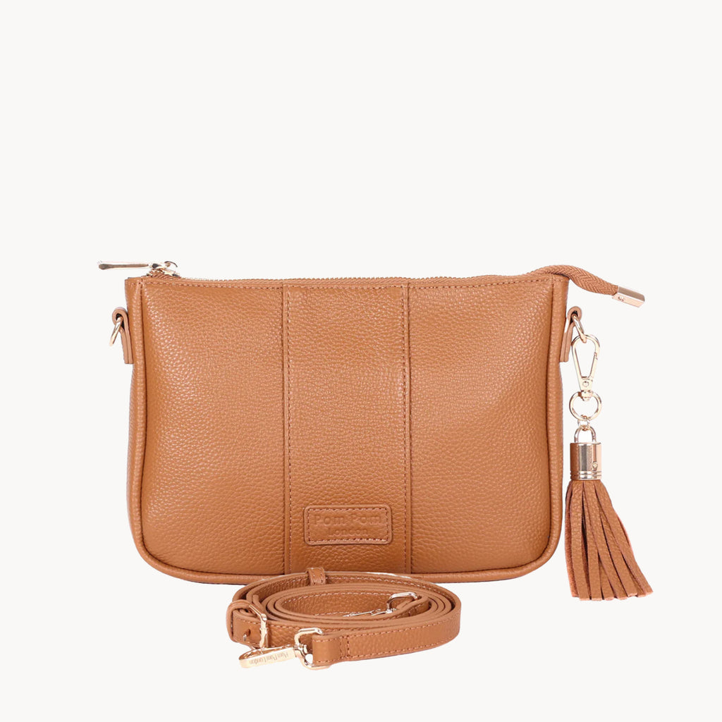 Tan leather handbag with a tassel on a white background