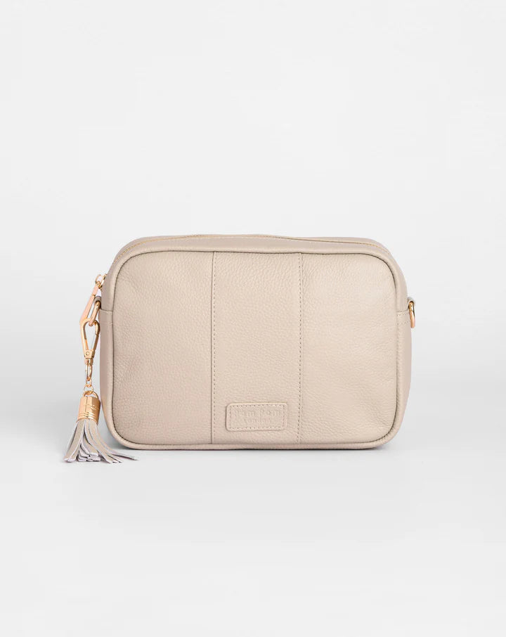 Beige crossbody bag with a tassel on a white background