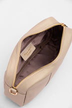 Beige crossbody bag with gold zipper and visible brand label on a light gray background