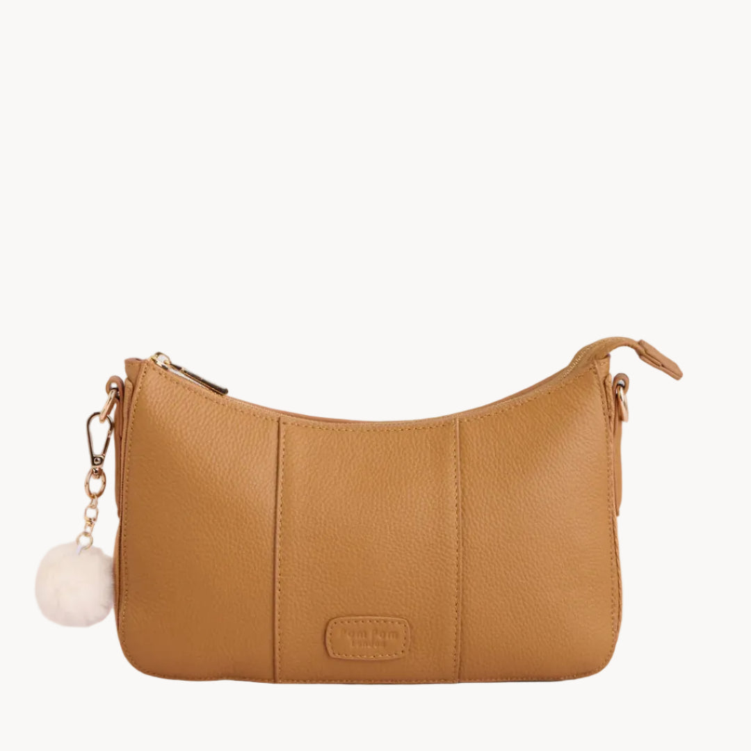 Tan handbag with a keychain on a light gray background
