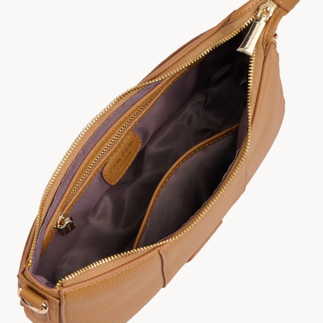 Tan leather pouch with gold zipper on a light gray background