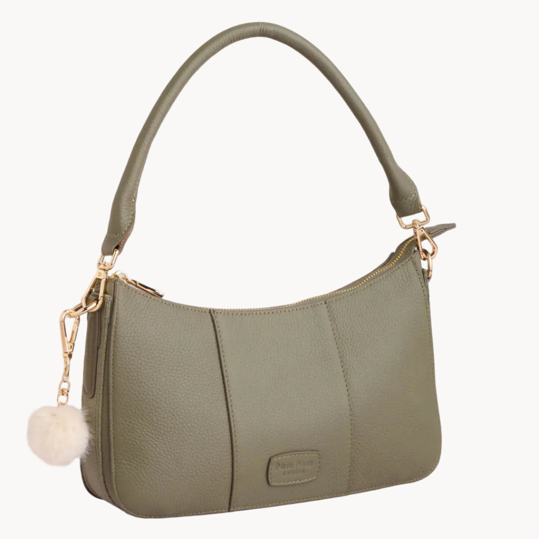 Green handbag with a gold chain and fluffy pom-pom on a light gray background