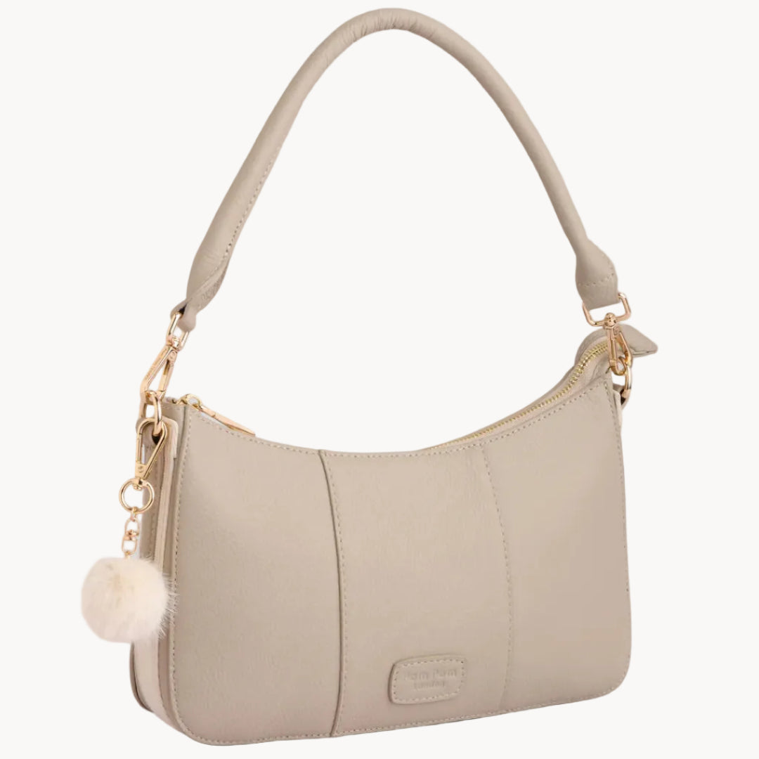 Stone handbag with a decorative chain and pom-pom on a light gray background