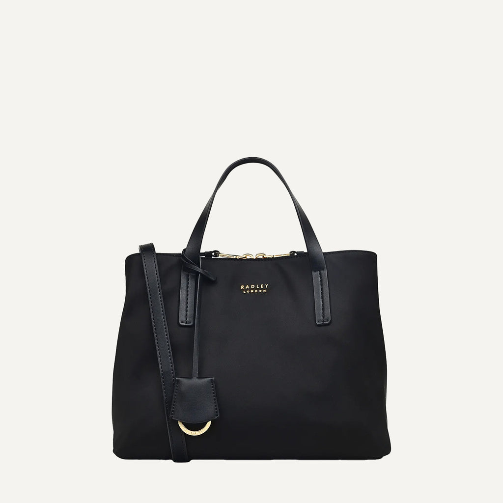 Black handbag with a strap on a light gray background