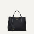 Black handbag with a strap on a light gray background