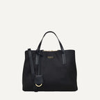 Black handbag with a strap on a light gray background