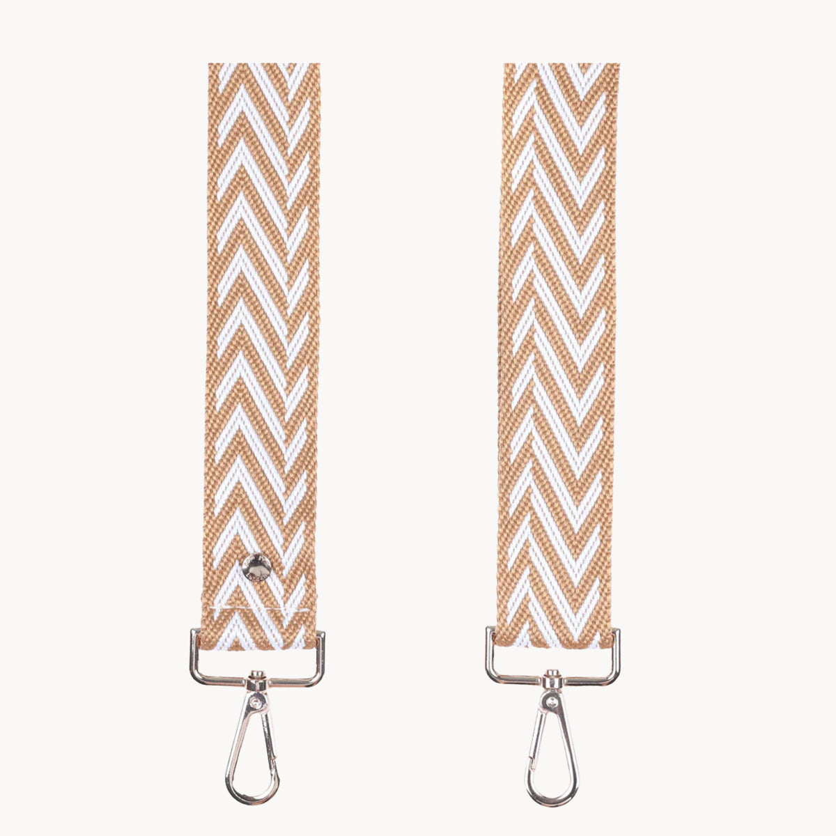 Two beige and white chevron patterned straps with metal hooks on a white background