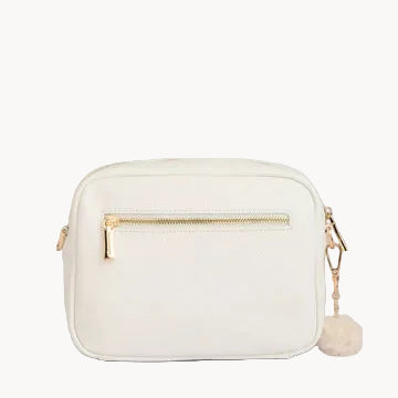 White handbag with gold zipper and strap on a gray background
