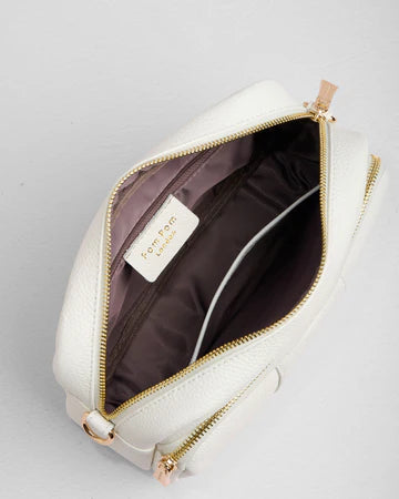 White leather bag with gold zipper on a light gray background