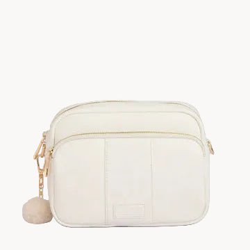 White crossbody bag with a pom-pom detail on a light gray background
