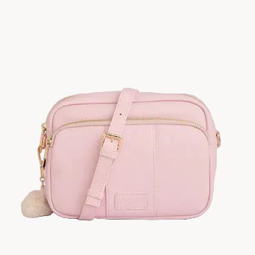 Pink crossbody bag with a fluffy pom-pom on a light gray background