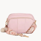 Pink crossbody bag with geometric pattern on a light gray background