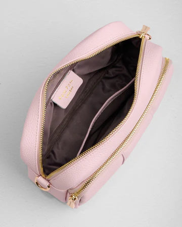 Pink bag with gold zipper on a gray background