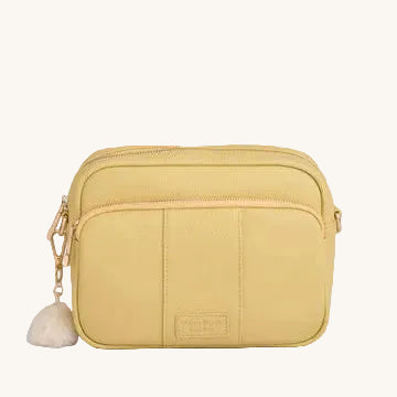 Yellow crossbody bag with a tassel on a gray background