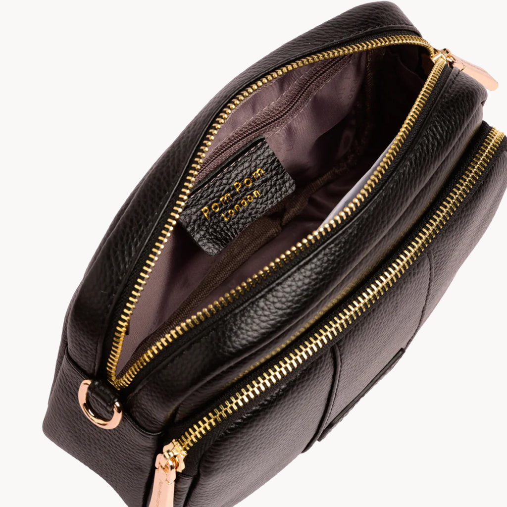 Black leather bag with gold zippers on a white background