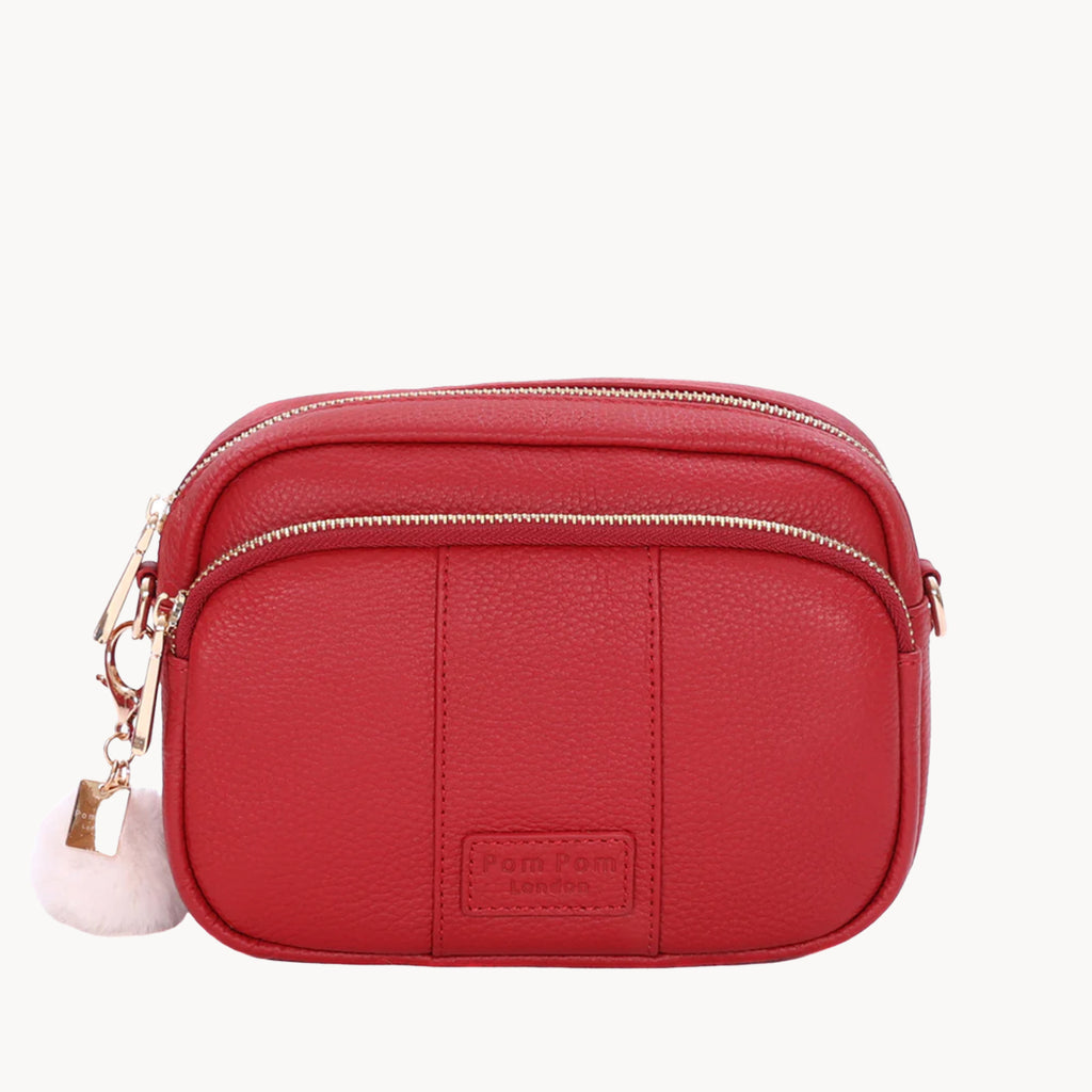 Red crossbody bag with a visible brand label on a white background