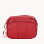 Red crossbody bag with a visible brand label on a white background