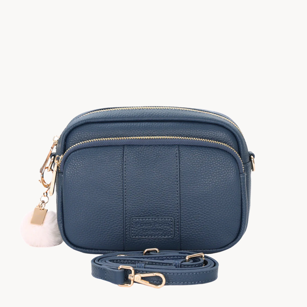 Blue leather crossbody bag with gold accents on a white background