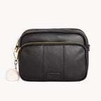 Black leather handbag with gold zipper on a white background
