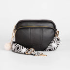 Black leather crossbody bag with a patterned strap on a white background