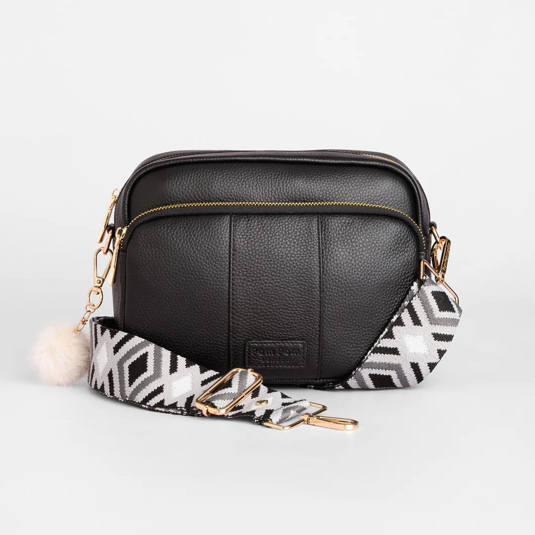 Black leather crossbody bag with a patterned strap on a white background