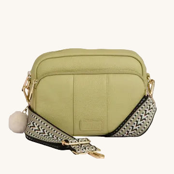 Green crossbody bag with a patterned strap on a light gray background