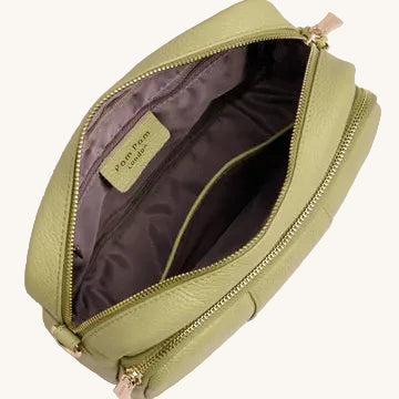 Green crossbody bag with open zipper on a light gray background