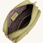 Green crossbody bag with open zipper on a light gray background