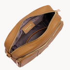 Brown leather pouch with gold zipper on a light gray background