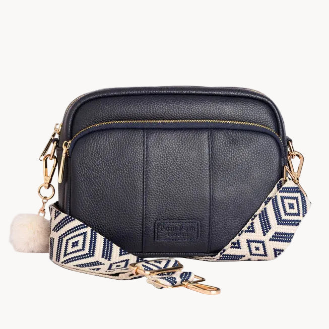 Navy handbag with a decorative strap on a light gray background