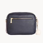 Navy blue handbag with gold zipper on a white background