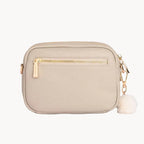 Stone crossbody bag with gold zipper on a light gray background