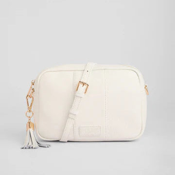 White handbag with gold accents on a light gray background