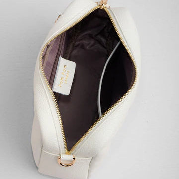 White leather bag with gold zipper on a light gray background