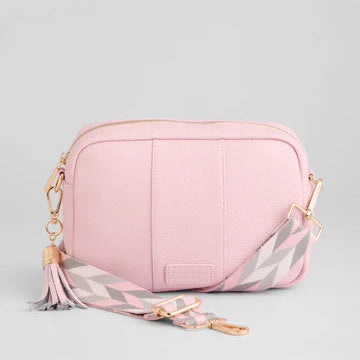 Pink crossbody bag with a strap on a light gray background