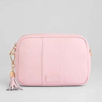 Pink crossbody bag with a tassel on a light gray background