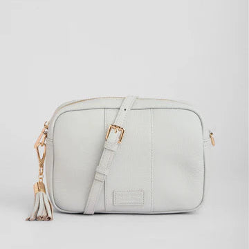 Light gray crossbody bag with gold accents on a light gray background