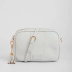 Light gray crossbody bag with gold accents on a light gray background