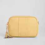 Yellow crossbody bag with a strap on a light gray background