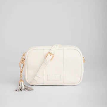 White handbag with a tassel on a light gray background
